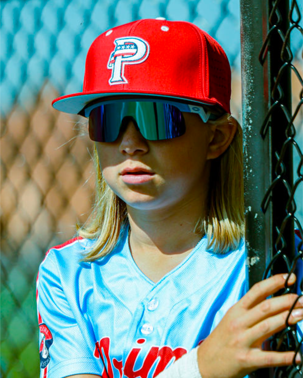 Young USA Prime baseball athlete wearing sunglasses and red USA Prime game hat fitted